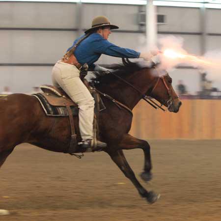 Kitty Lauman riding her horse at mounted shooting clinic